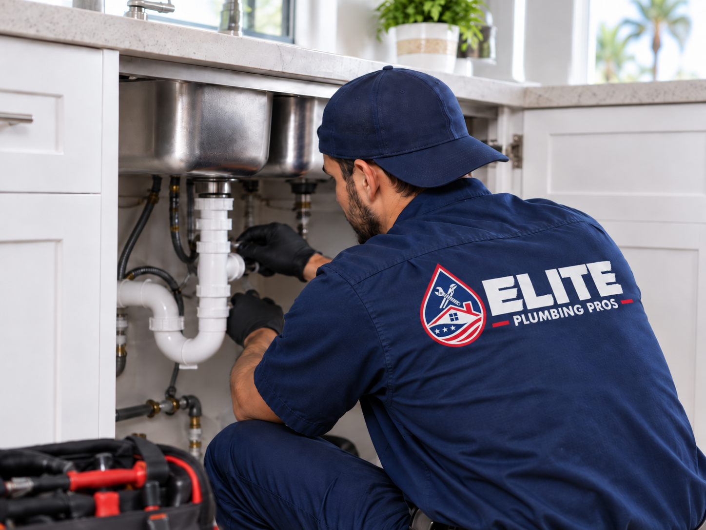 Elite Plumbing Pros plumber repairing pipes under a kitchen sink